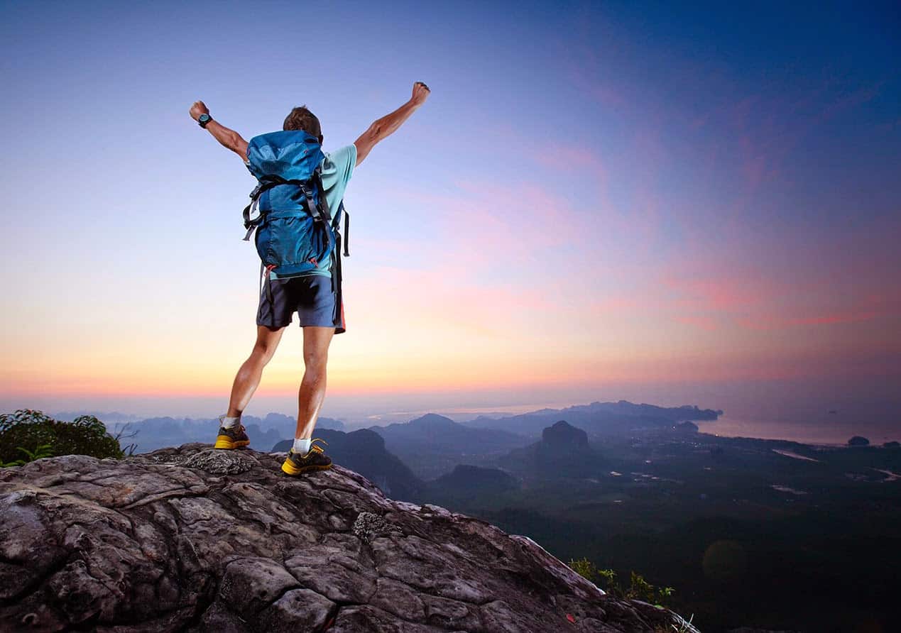 .world domain men raising arms on mountain peak with clear skies